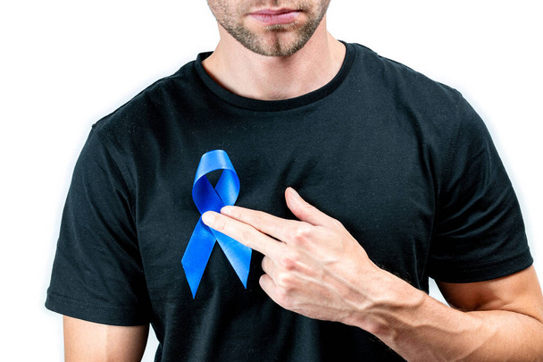 Blauw prostaatlint. Bewustzijnskanker van de gezondheid van mannen. Hipster mannen in zwart shirt met blauw lint in handen geïsoleerd op witte achtergrond. November en Internationale Herendag - Foto, afbeelding