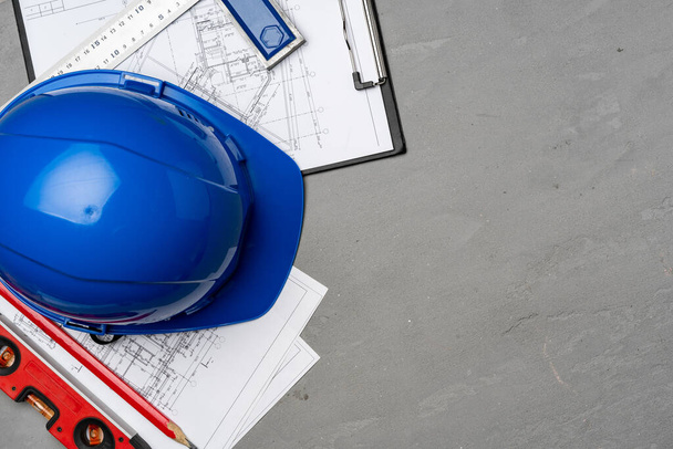 Construction worker hardhat, blueprints and .construction level, top view - 写真・画像