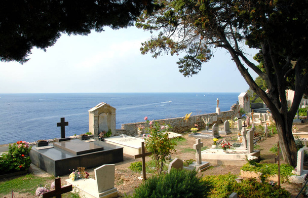 sugestywny cmentarz Porto Venere z widokiem na Morze Śródziemne i fortecę, na której stoi romański kościół San Pietro. - Zdjęcie, obraz