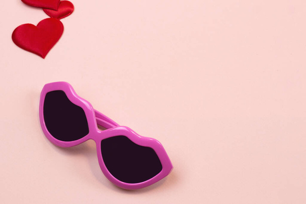 occhiali rosa e cuori su uno sfondo chiaro. Copia spazio - Foto, immagini