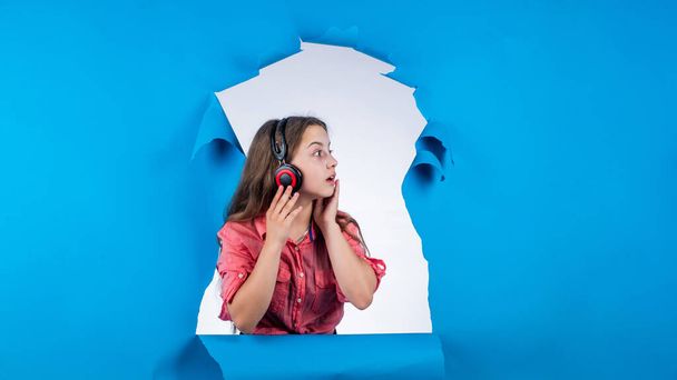 teen girl listening music in headphones. happy childhood. pretty child on studio background. - Fotó, kép