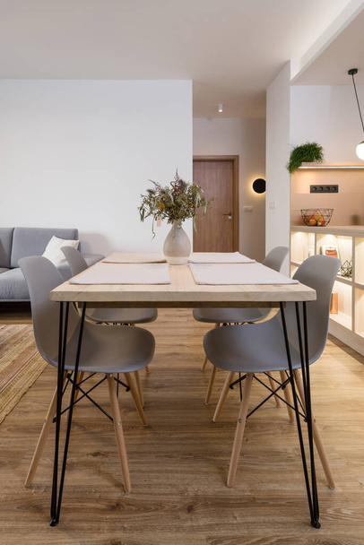 Mesa de comedor entre cocina y sala de estar en apartamento contemporáneo - Foto, imagen