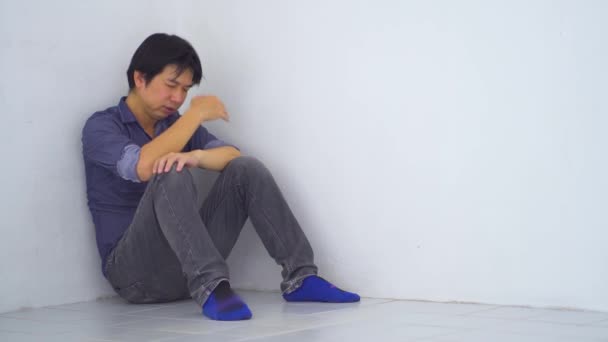 Triste uomo d'affari asiatico sconvolto seduto in un angolo appoggiato al muro nel vecchio condominio, Violenza domestica, problemi familiari, Stress, violenza, Il concetto di depressione e suicidio - Filmati, video