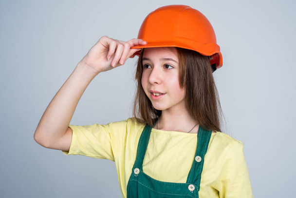 teen girl in helmet and boilersuit. child wear hard hat. kid builder on construction site. worker engineer. architect in workshop. renovation and repair. Confident mechanic - Fotó, kép
