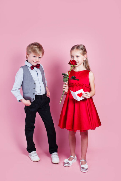 Valentines day surprise. Little boy in love giving cute girl red rose , - Фото, изображение