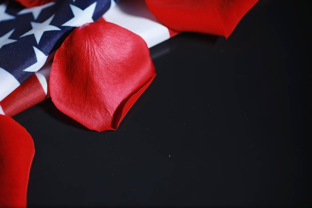Bandiera americana e fiore di rosa sul tavolo. Simbolo degli Stati Uniti d'America e petali rossi. Patriottismo e memoria. - Foto, immagini