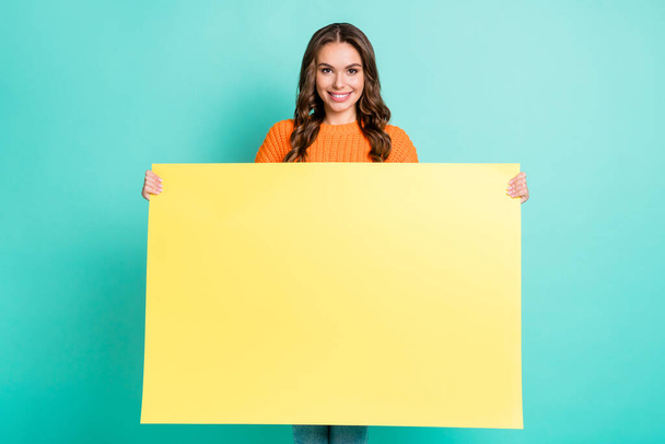 Photo of young attractive girl happy positive smile hold poster billboard advertisement isolated over teal color background - Φωτογραφία, εικόνα