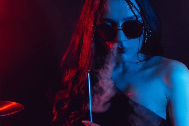 Hookah atmosphere. Large portrait of a girl who enjoys smoking a hookah, sheesha. - Valokuva, kuva