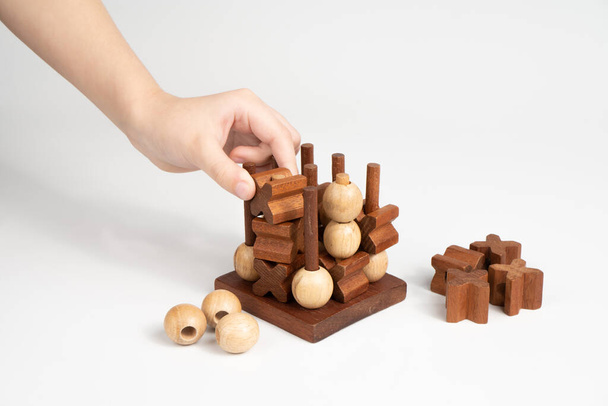 子供は、 ic-tac-toothのゲームで勝利の動きをします。三次元木製ボリュームフィールドのためのチック-タック-つま先の競争。戦いの勝者だ. - 写真・画像