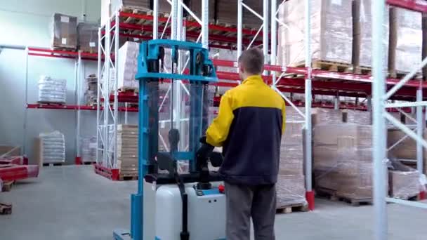 skladník pracovník řidič v uniformě nakládání lepenkových krabic vysokozdvižným vozíkem stohovací nakladač - Záběry, video