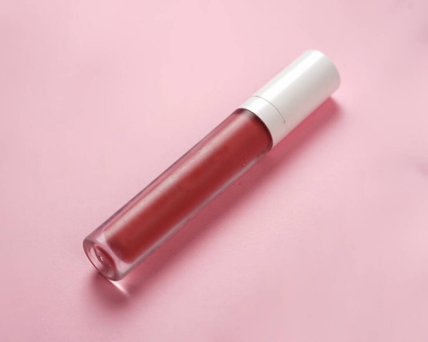 Liquid lipstick, Lip gloss in elegant glass bottle with white lid. Trendy colors of the season. Texture of lip gloss isolated on white background. Mock-up of packages for decorative cosmetic product.  - Photo, Image