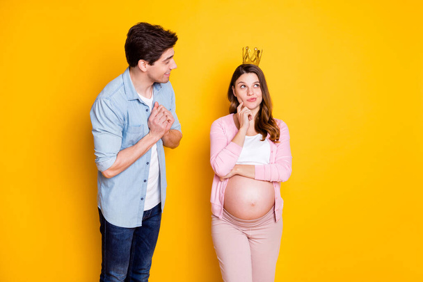 Photo of young couple stand pregnant woman think wear crown casual cloth isolated on yellow background - Photo, image