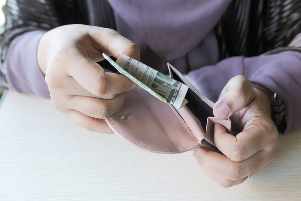財布の中の女性の手の節約の現金を閉じる  - 写真・画像