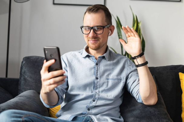 A guy with a smartphone talking online - Фото, зображення