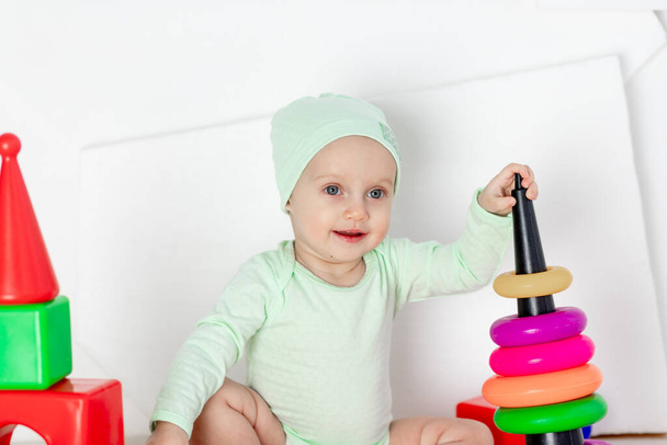 baby playing with toys in the children's room at home, the concept of development and leisure of toddlers - Foto, Imagem