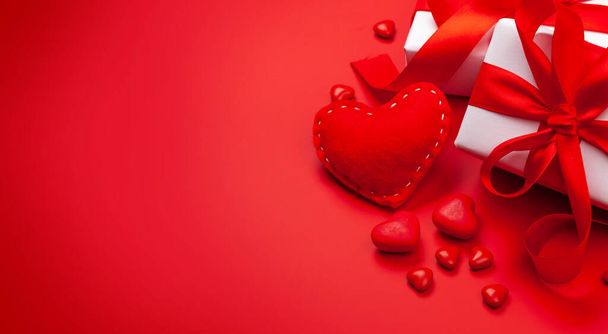 Dia dos Namorados modelo de cartão de saudação. Caixas de presente, decoração do coração e doces sobre fundo vermelho. Com espaço de cópia - Foto, Imagem