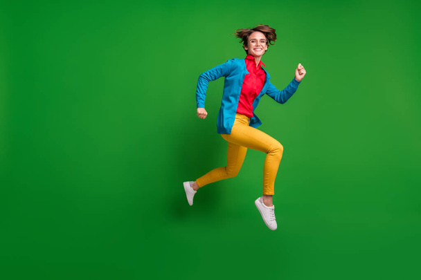 Full length body size side profile photo of jumping high hurrying up cheerful girl isolated on vivid green color background with copyspace - Фото, изображение