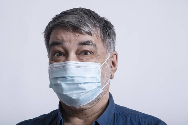 Portrait of a scared man in a protective medical mask. - Zdjęcie, obraz