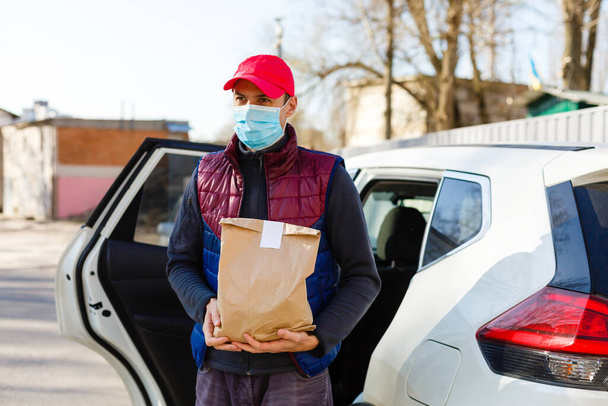 保護マスクと医療用手袋の宅配便は持ち帰り用の食品を提供します。隔離下での配送サービス,病気の発生,コロナウイルスcovid-19パンデミック条件. - 写真・画像