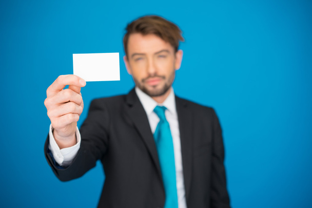 homem de negócios bonito mostrando cartão de visita em branco
 - Foto, Imagem