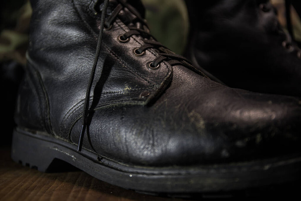 War concept. Old military shoe in a dark toned foggy background. Creative concept of military aggression. Selective focus - Photo, Image
