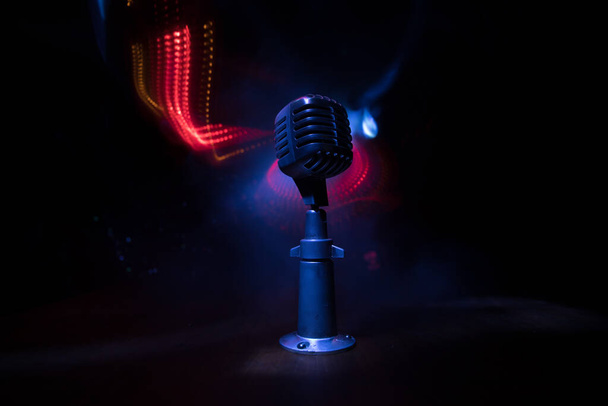 Retro style microphone on background with backlight. Vintage silver Microphone for sound, music, karaoke. Speech broadcast equipment. Live pop, rock musical performance. Selective focus - Photo, Image