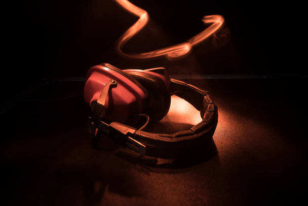 Dj music club concept. Close up old vintage headphones on dark background with colorful light. Selective focus - Φωτογραφία, εικόνα