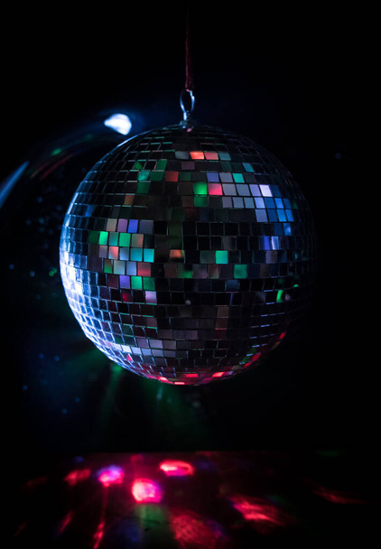 Bunte Disco-Spiegelkugel beleuchtet Nachtclub Hintergrund. Party zündet Discokugel an. Selektiver Fokus - Foto, Bild