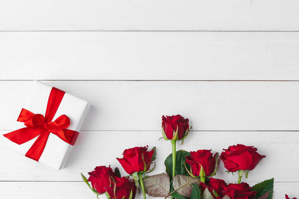 St. Valentines Day. Red roses and gift box on wooden table - Foto, Imagen