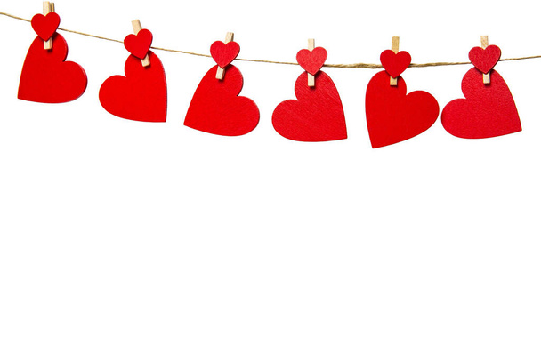 Червоні серця з підкладками, що звисають з мотузкою, ізольовані на білому тлі. Valentines Day, Healthcare, Mothers Day concept, copy space - Фото, зображення