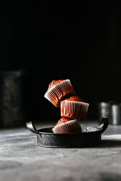 csokoládé muffinok porcukorral sötét alapon - Fotó, kép