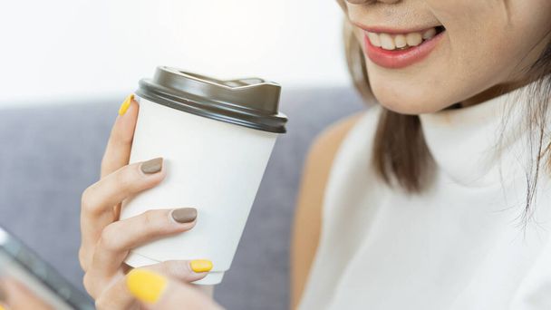 Une tasse de café dans la main d'une fille qui s'apprête à boire - Photo, image