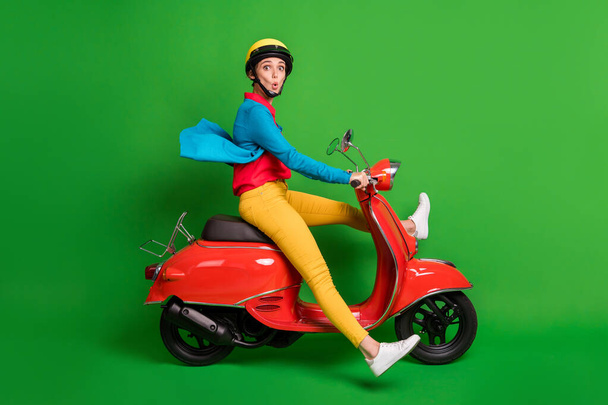 Full size profile side photo of young beautiful shocked amazed girl ride fast red moped isolated on green color background - Φωτογραφία, εικόνα