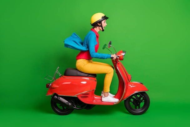 Πλήρες μέγεθος προφίλ πλευρά φωτογραφία του νεαρού σοκαρισμένος κορίτσι βόλτα γρήγορα σε κόκκινο μοτοσικλέτα που απομονώνονται στο πράσινο φόντο χρώμα - Φωτογραφία, εικόνα
