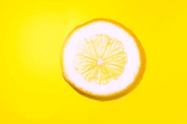 Citron na žlutém pozadí. Nakrájený citron na slunci - Fotografie, Obrázek