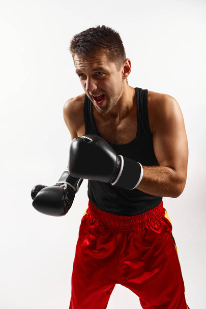 sporty man in black boxing gloves punching - 写真・画像