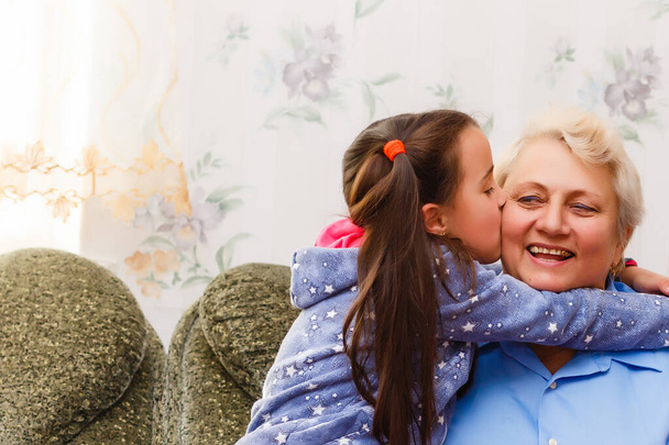 Adulto sorrindo netos abraça avó idosa feliz por ver falta dela, visita de parentes amorosos desfrutar de comunicação, abraçar como símbolo de conexão, amor e conceito de apoio - Foto, Imagem