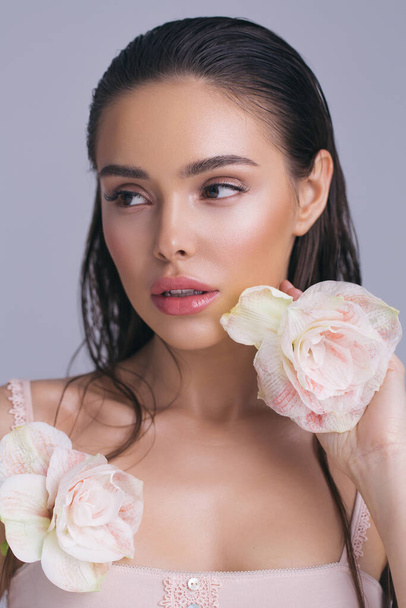 Closeup face of an young beautiful woman with makeup and flower - Fotó, kép