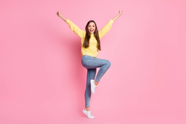 Full size photo of young beautiful crazy ecstatic positive good mood girl raise fists leg isolated on pink color background - Photo, image