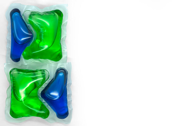 cápsulas para lavagem com gel azul-verde no espaço de cópia de fundo branco - Foto, Imagem