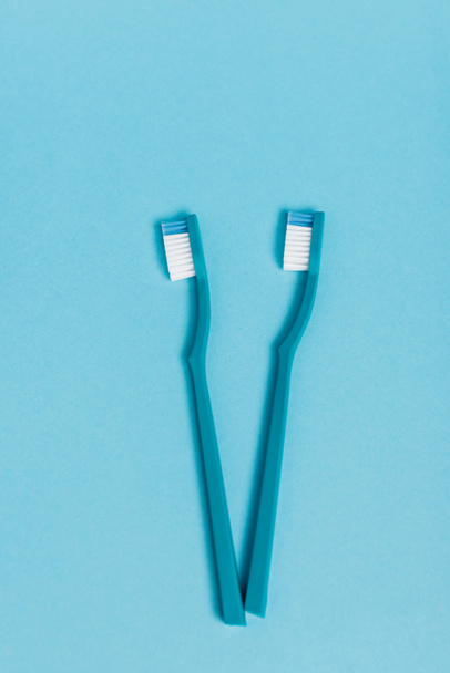 Vista superior de novas escovas de dentes no fundo azul - Foto, Imagem