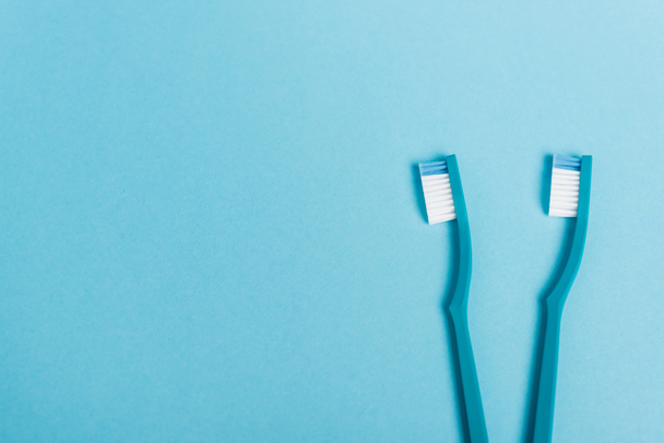 Fotokopi alanı olan mavi arkaplandaki diş fırçalarının üst görünümü  - Fotoğraf, Görsel