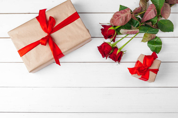 St. Valentines Day. Red roses and gift box on wooden table - Foto, Bild