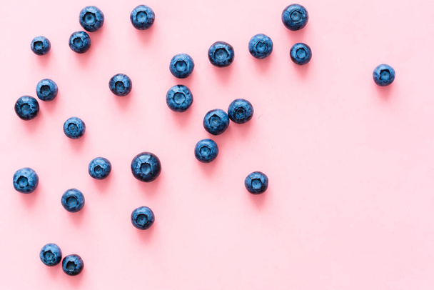 blueberries on pink background. Top view. Flat lay - Foto, afbeelding