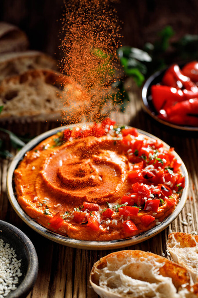 Pieczony hummus z czerwonej papryki z oliwą z oliwek posypany papryką w proszku, widok z bliska - Zdjęcie, obraz