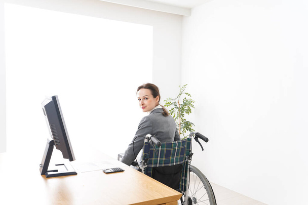 Giovane donna che lavora in sedia a rotelle - Foto, immagini