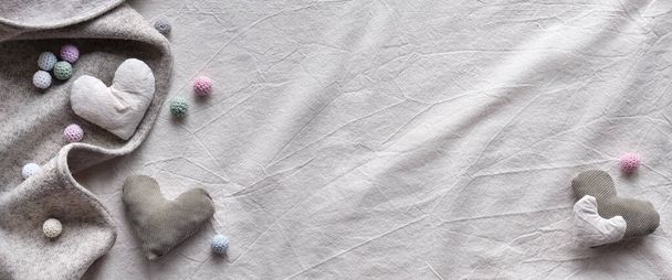 Hand made textile hearts and balls on cotton background. Textile handicraft in neutral colors. Wintertime cherry flower twigs. Monochromatic look, banner panoramic composition with copy-space. - Valokuva, kuva