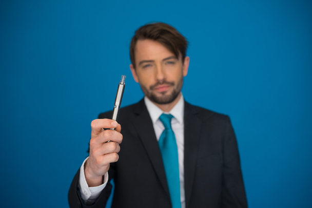 e-sigara giyen takım elbise ve kravat mavi ile işadamı - Fotoğraf, Görsel