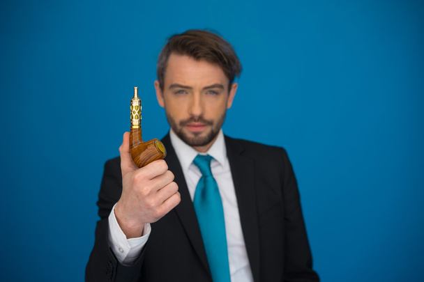 Geschäftsmann mit E-Zigarette trägt Anzug und Krawatte auf blauem Grund - Foto, Bild