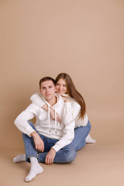 A handsome guy sits and is hugged by a girl. Happy Couple in Love - Фото, изображение